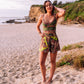 woman at the beach wearing a green paisley print cropped singlet top and shorts coordinates set