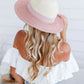 woman wearing a colored brim summer straw hat - blush pink