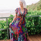 woman wearing a purple tropical floral print flutter sleeve tiered maxi dress