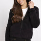 woman wearing a lynney teddy faux fur plush hooded jacket in black