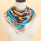 teal and gold bandana head scarf worn on a manequins neck