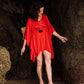 woman on the shore wearing a red kaftan dress by cave woman