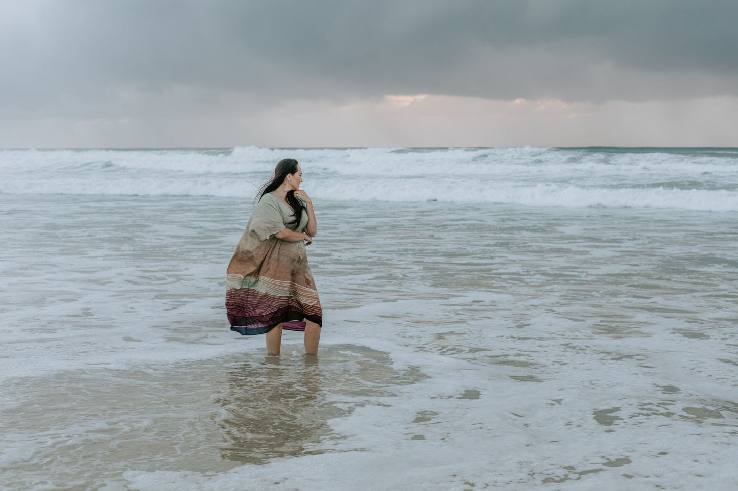 woman dipping her feet in the water at the beach wearing Amera Eid Kaftan - Nazli Design