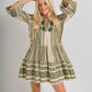 woman wearing aztec pattern bell sleeve tiered dress with floral embroidery - white and sage