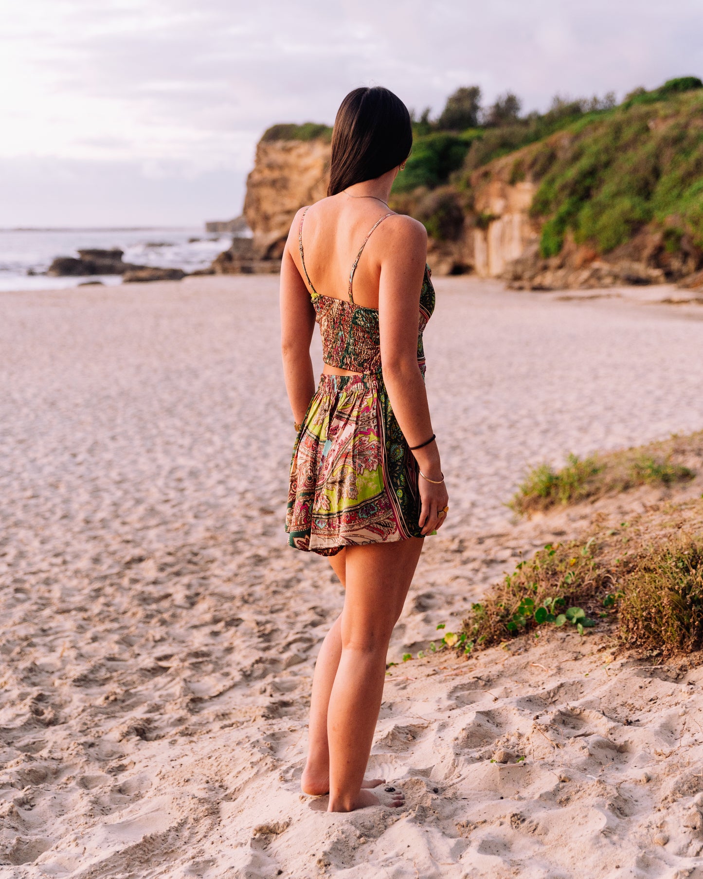 woman at the beach showing the back of smocked singlet top and shorts