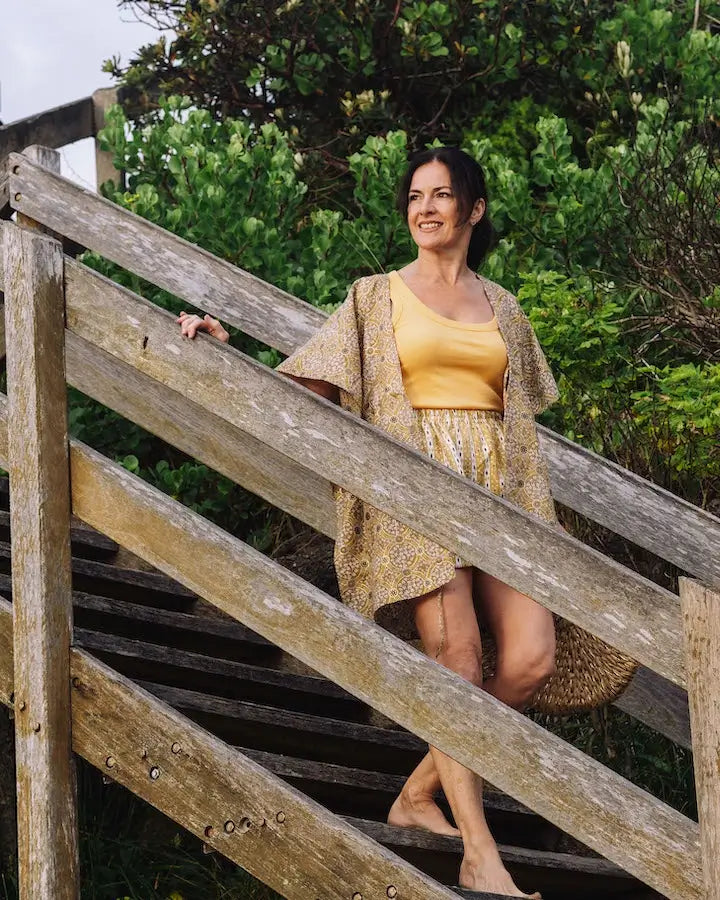 a woman walking down a wooden stairs wearing Arabesque Short & Kimono Set