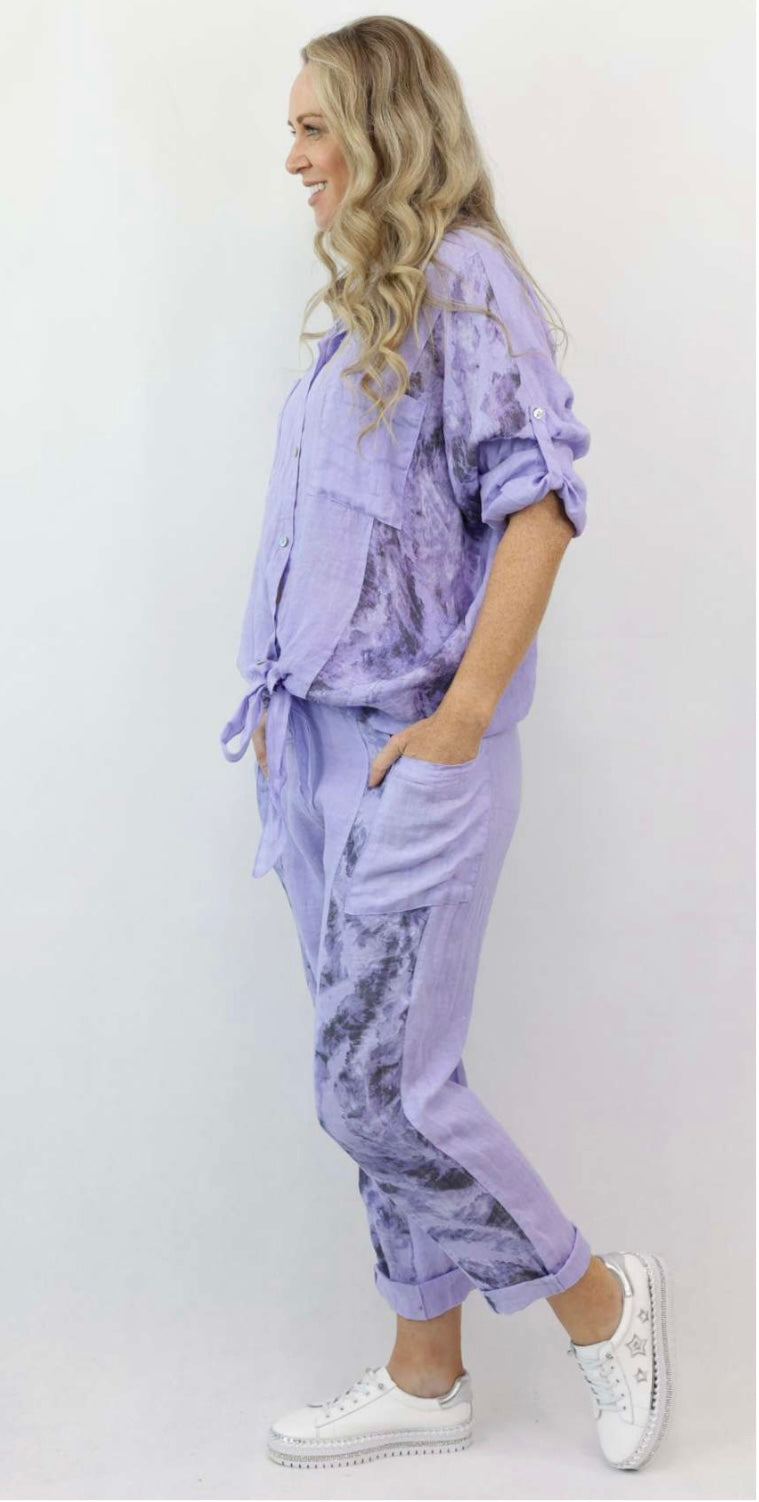 woman wearing a lavender top and bottom with tie dye accent on the side