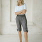 woman wearing a dark grey peace out shorts with wide smocked waistband 