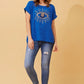 woman wearing a glittered evil eye blue top and jeans