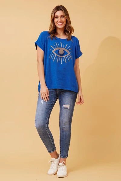 woman wearing a glittered evil eye blue top and jeans