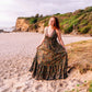 woman at the beach wearing a halter neck tiered maxi dress in paisley print