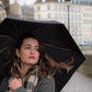 woman using the Anatole Jane Collapsible Micro Umbrella with a nice building as a background