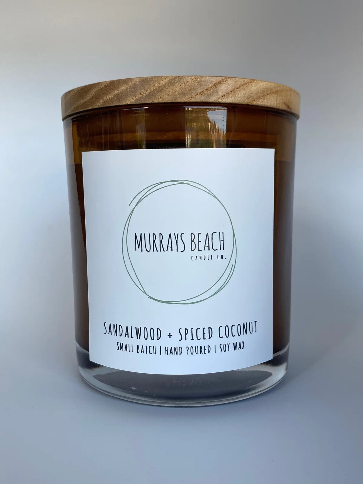 murrays beach candle co. in a glass jar with cover (sandalwood + spliced coconut)