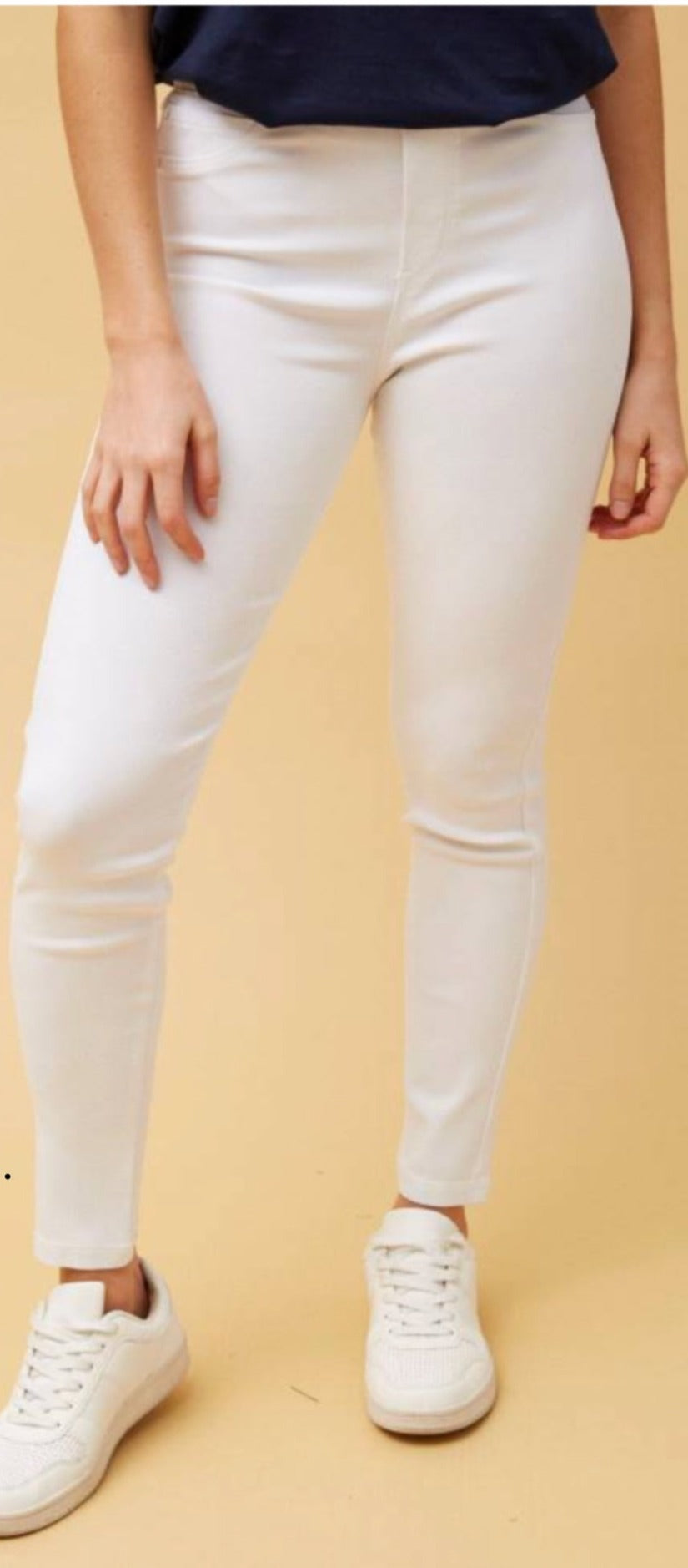 woman wearing white jeggings and white shows