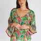 woman wearing a parrot tropical print top with tie neck tassel