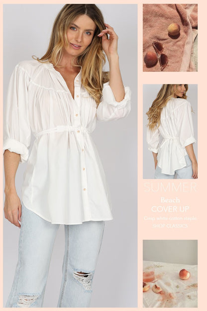 woman wearing a mandarin collared balloon sleeve cinched waist button down shirt in white