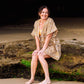 woman sitting at the sea side on a rock wearing a Penelope Arabesque Shorts & Kimono Set