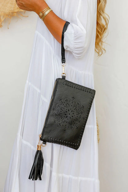 woman wearing white tiered dress with mandala cut purse bag with tassel in black