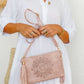 woman wearing white tiered dress with mandala cut crossbody bag with tassel in dusty pink