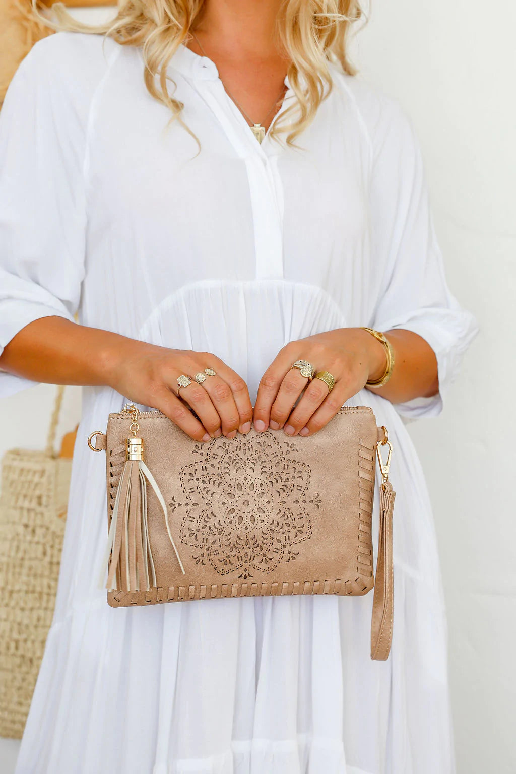 woman wearing white tiered dress with mandala cut crossbody bag with tassel in beige