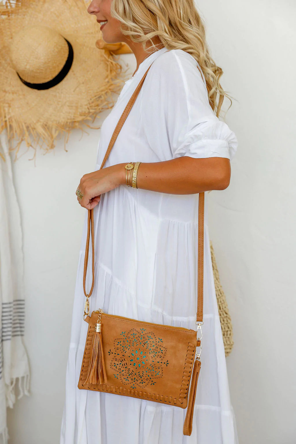 woman wearing white tiered dress with mandala cut crossbody bag with tassel in brown