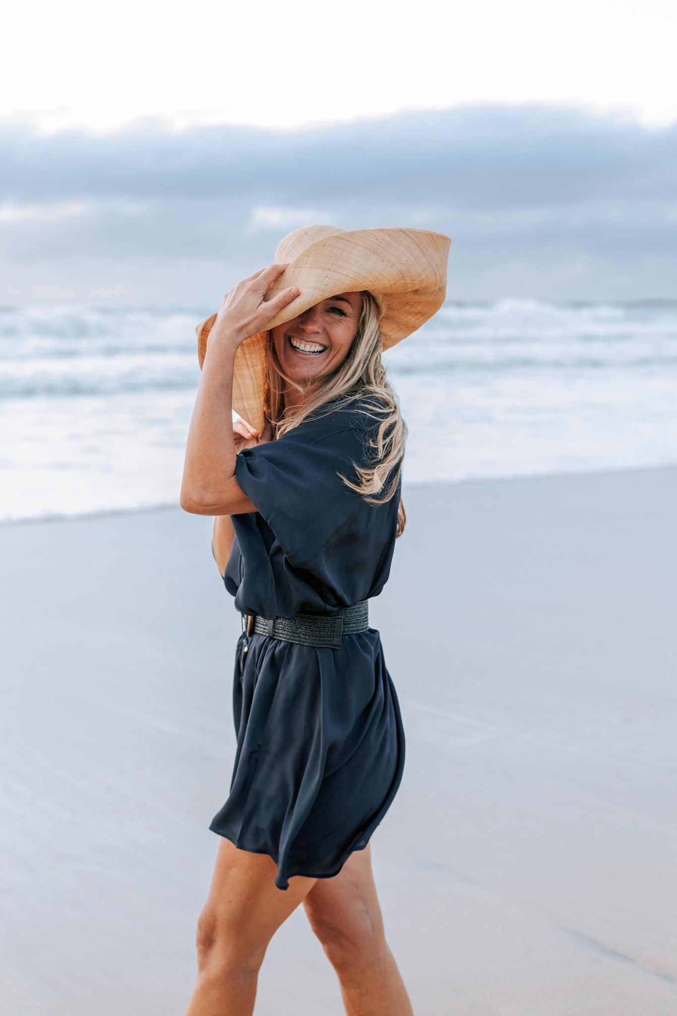 woman on the beach wearing an Amera Eid Silk Kaftans  and a straw hat