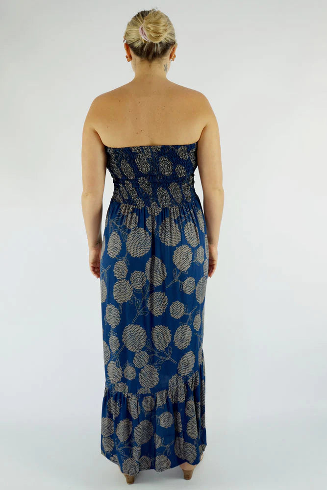 woman wearing a navy blue floral smocked strapless front slit salsa dress back view