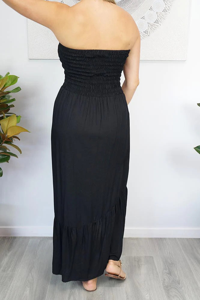 woman wearing a black strapless smocked salsa dress with front slitwoman wearing a black strapless smocked salsa dress with front slit back view
