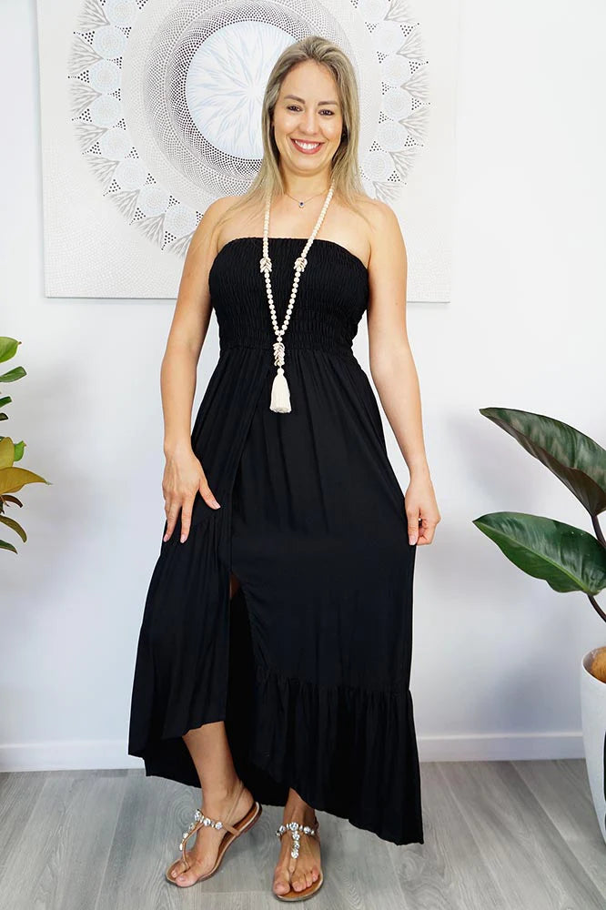 woman wearing a black strapless smocked salsa dress with front slit