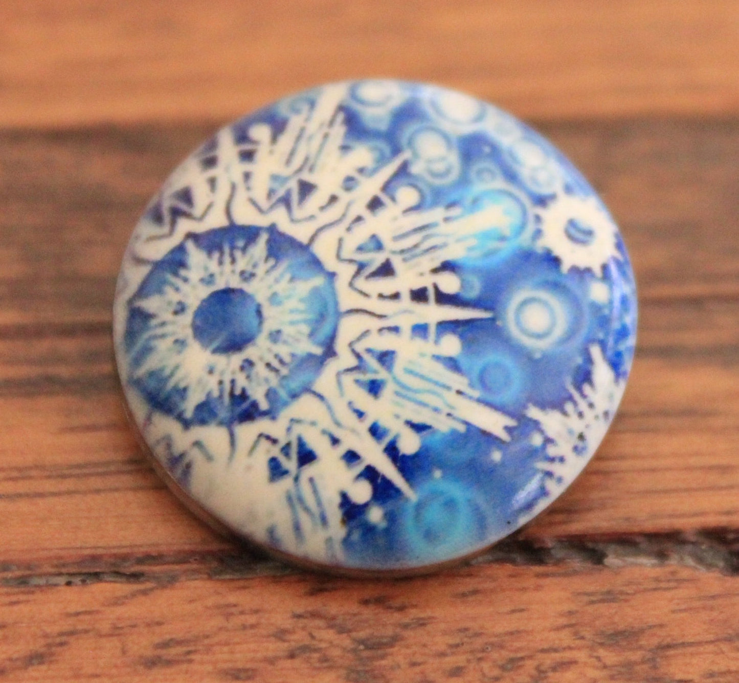 snowflakes pattern in blue painted stone button