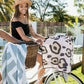 woman on a bicycle with The Brighton Pink Leopard Spots Sand Free Towel with Bag