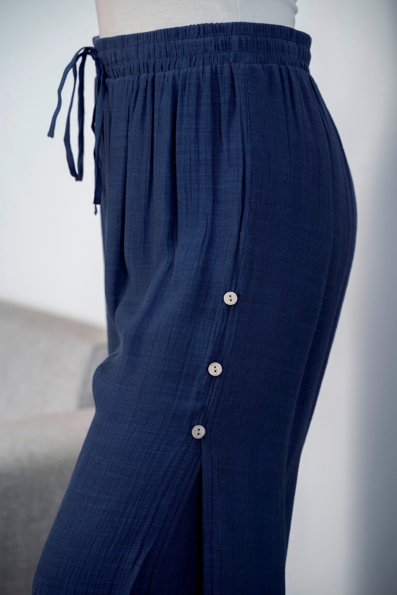 3/4 length loose capri trousers with tie on waist in navy blue color with three buttons on the side