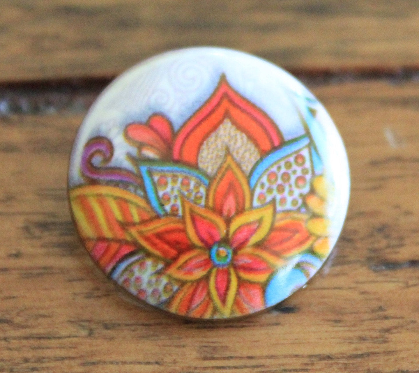 multicolored mandala pattern on a painted stone button