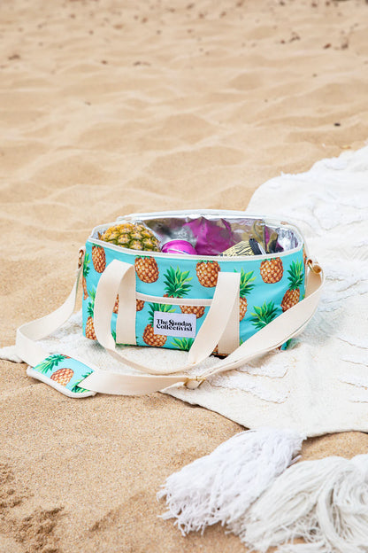 Collapsible Cooler Bag in Pineapple Print by The Sunday Collectivist - PACIFICA 32cm X 20cm X 17cm on a beach sand with towel