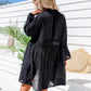 woman wearing floral two piece bikini covered up with a free spirit crochet trimmed sheer black kimono with tassels back view