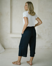 woman wearing a white top and a Freez Sicily Shirred Waistband Loose Cropped Trousers with Pockets in ink color back view