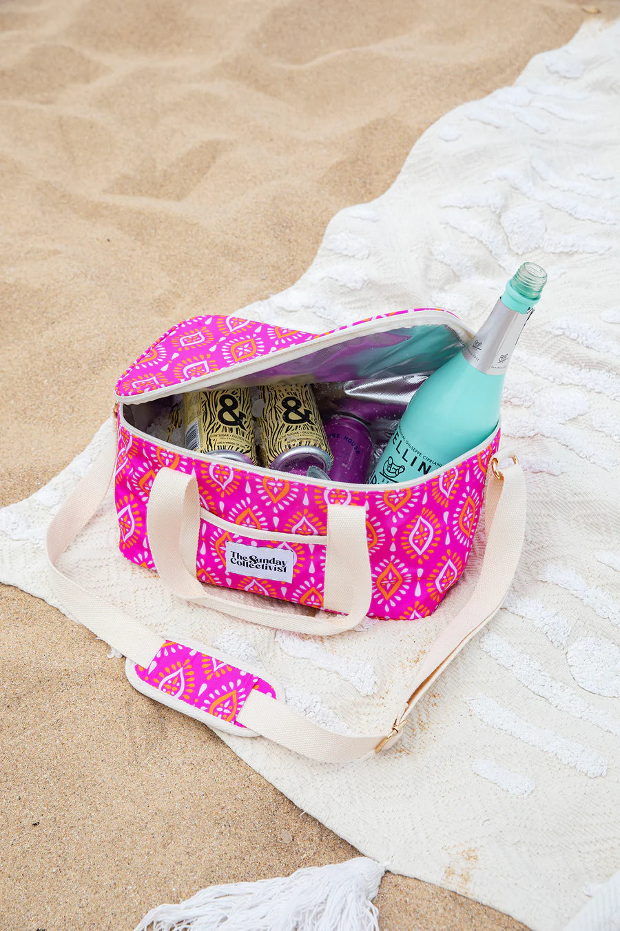 luna cooler bag by the sunday collectivist in hot pink at the beach sand