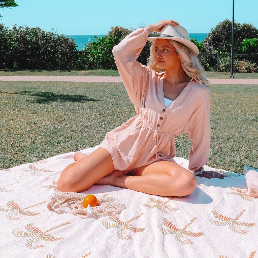 woman sitting on Sand Free Towel - The Mooloolaba Palm Tree in beige