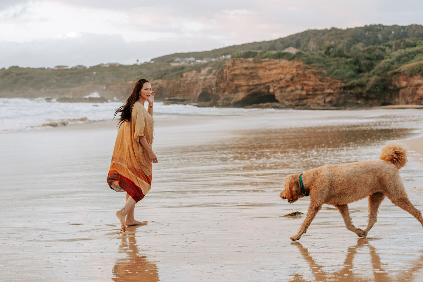woman on the beach wearing Amera Eid Kaftan - Layali Design with a dog
